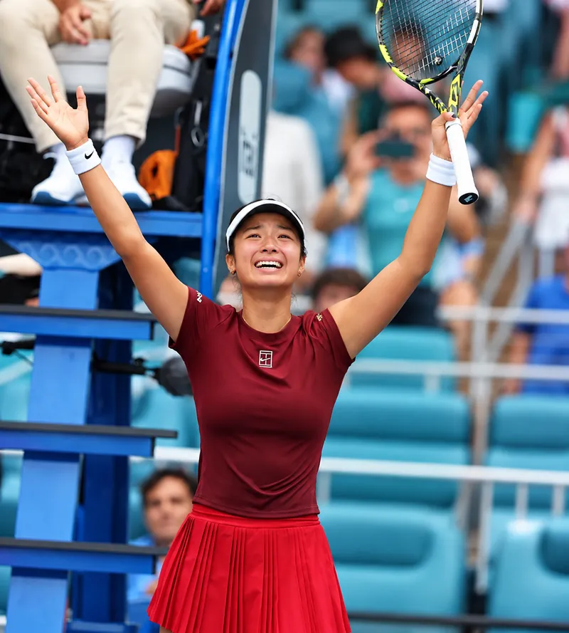Alex Eala celebrating a win with both arms raised
