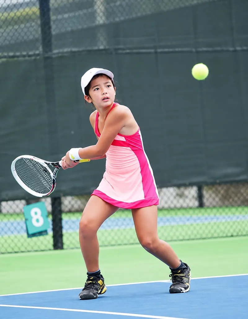Young Alex Eala as a junior player preparing for a forehand