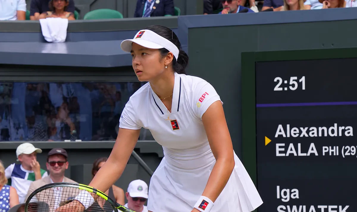 Alex Eala preparing to serve at Wimbledon, scoreboard Eala vs Swiatek