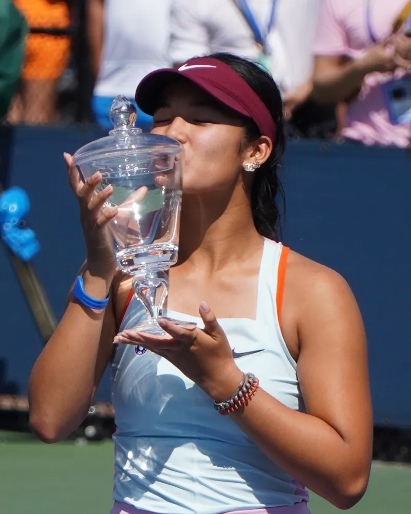 Alex Eala holding a trophy, photo from her profile on the Rafa Nadal Academy website